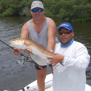 Captain Craig and a customer hold a huge redfish